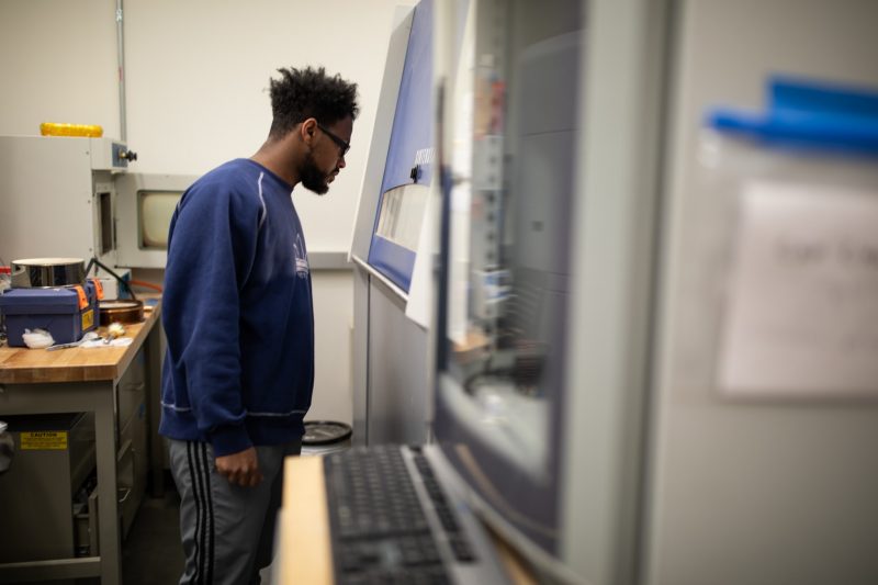 A person looks into a 3-D printer.