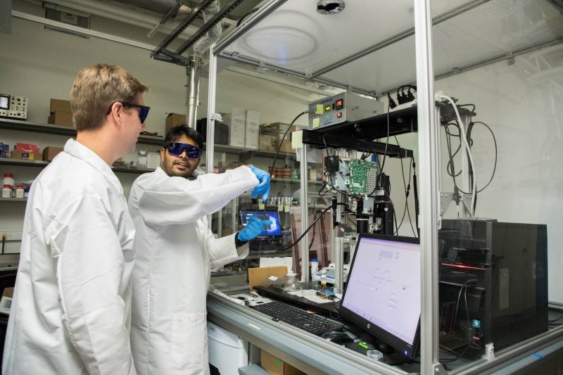 A grad student in the DREAMS lab shows off the large area vat photopolymerization system